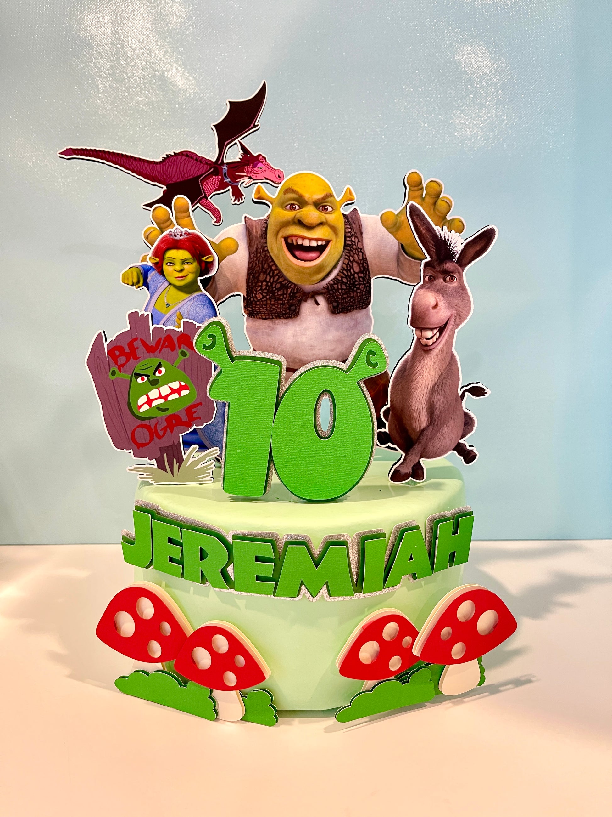 Shrek cake topper featuring Shrek, Donkey, and Fiona characters on a birthday cake